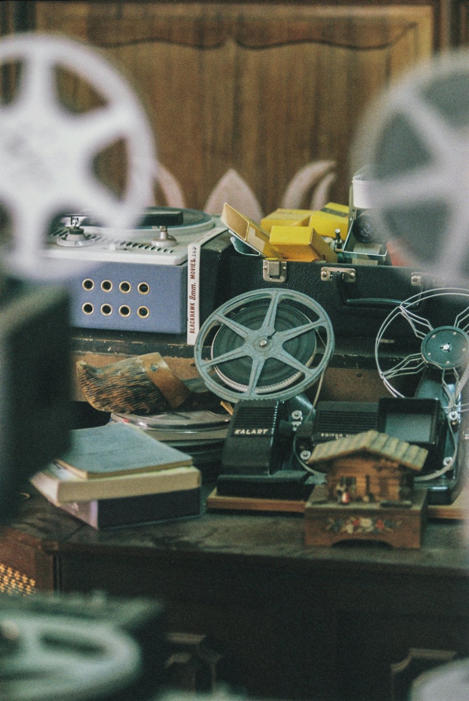 Vintage film reels and editing equipment arranged on wooden surface.
