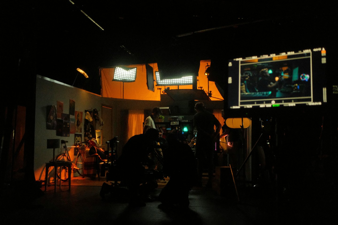 Film crew working on a dimly lit studio set.