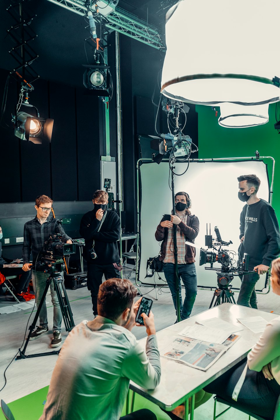 A film crew works together in a professional studio space.