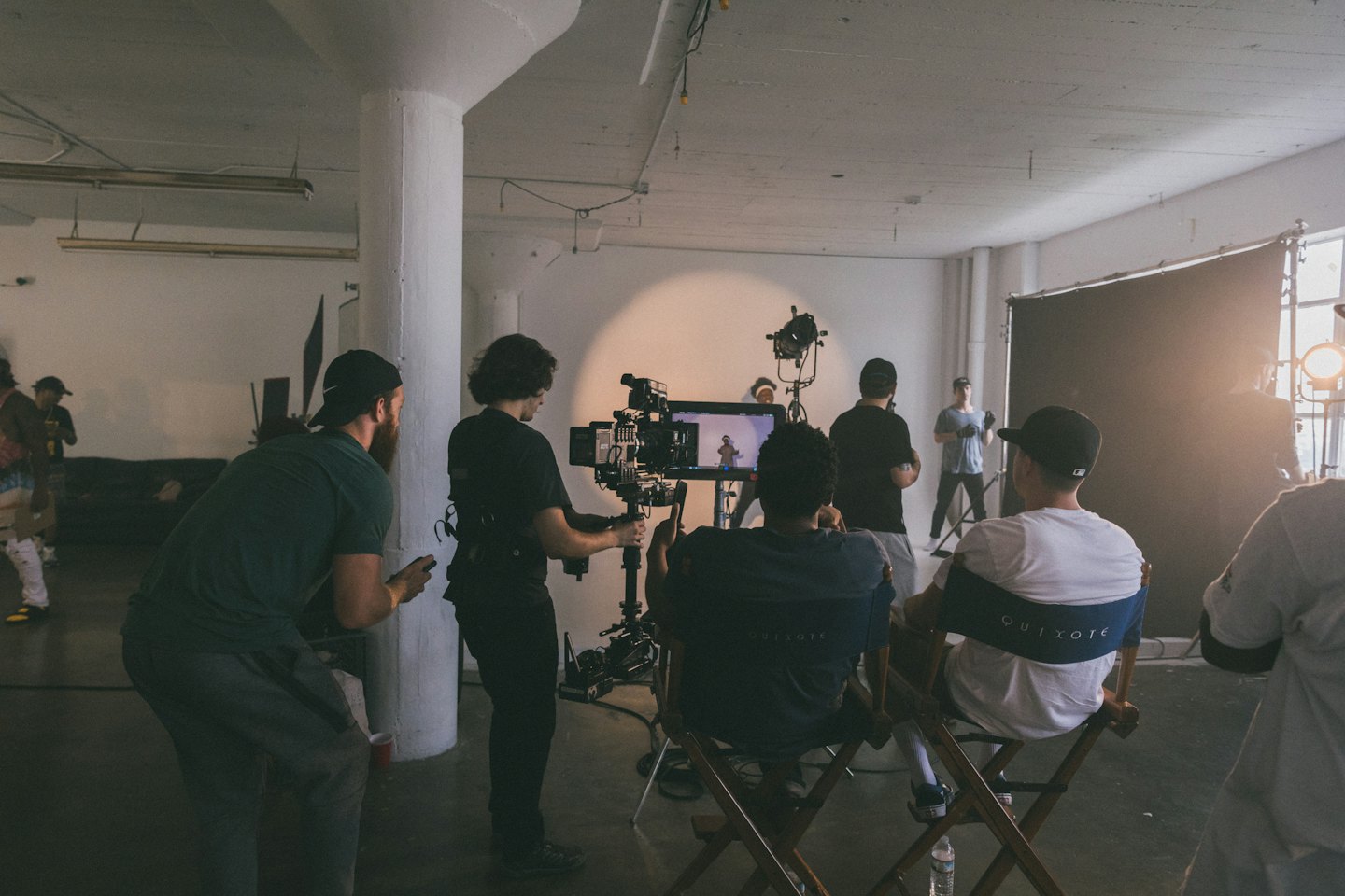 Men filming a video production with a camera rig and spotlight.